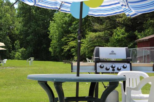 a picnic table with an umbrella next to a grill at Martin's Inn in Cornwall