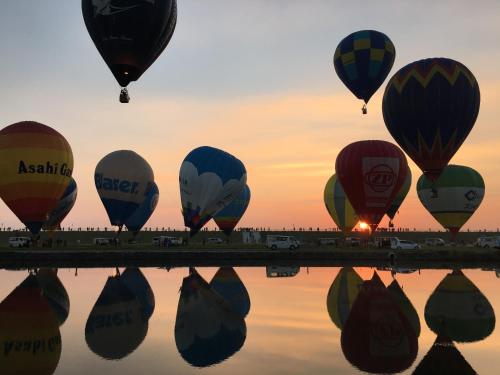 a group of hot air balloons reflecting in the water at Share Creative&Bed adonoan in Takeo