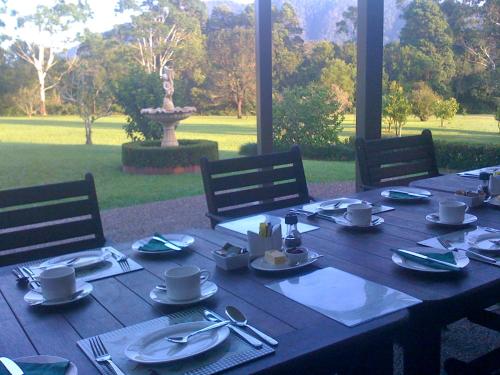 een houten tafel met borden en keukengerei erop bij Yarrahapinni Homestead in Yarrahapinni