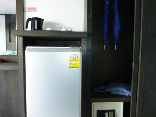 einen weißen Kühlschrank in einer Küche mit Regal in der Unterkunft Kathalee Beach Resort & Spa in Ko Lipe