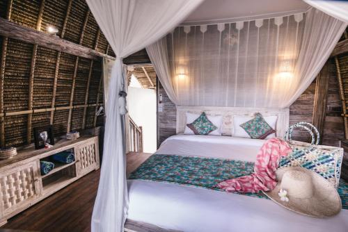 a bedroom with a bed with a swing at Dream Beach Huts in Nusa Lembongan