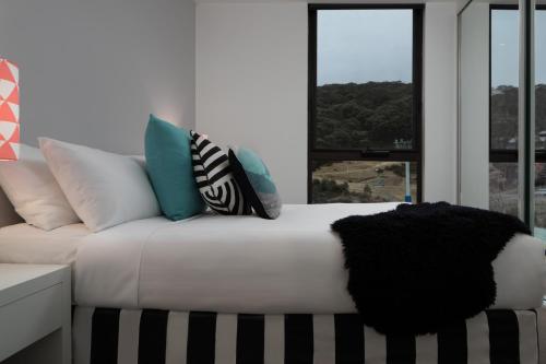 a bed with pillows and pillows on top of it at QT Falls Creek in Falls Creek