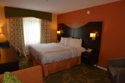 a hotel room with a large bed with orange walls at Trailsman Lodge in Baddeck