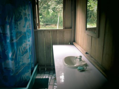a bathroom with a sink and a window at Rumi Wilco Ecolodge & Nature Reserve-Cabañas & Camping in Vilcabamba
