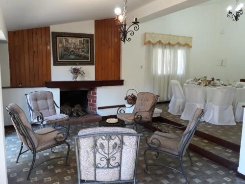 sala de estar con mesa, sillas y chimenea en Quinta Valvanera en Salta