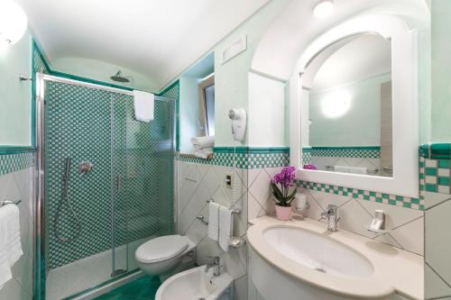 La salle de bains est pourvue d'un lavabo, d'une douche et de toilettes. dans l'établissement L'Angolo dei Sogni, à Ravello