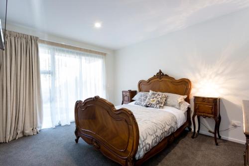 a bedroom with a large bed and a window at The Beach House in Dunedin