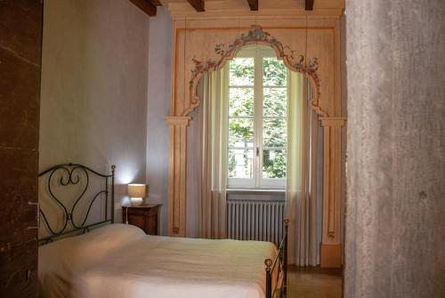 una camera da letto con un letto e una grande finestra di B&B Dimora Delle Donnole Bergamo Alta a Bergamo
