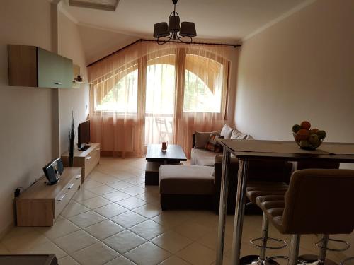 a living room with a couch and a table at Napsugár Apartman in Balatonlelle