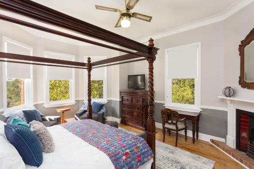 a bedroom with a canopy bed and a television at Palmyra B&B in Rainbow Flat