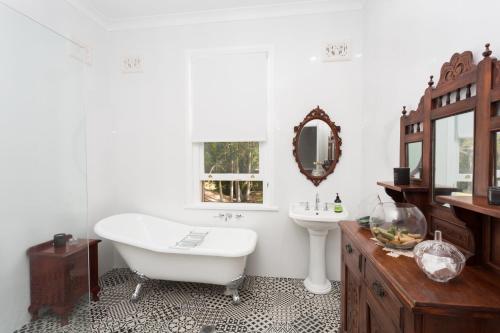 a bathroom with a tub and a sink and a mirror at Palmyra B&B in Rainbow Flat