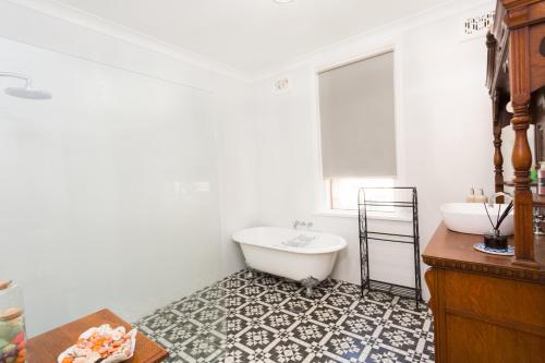 a bathroom with a white tub and a sink at Palmyra B&B in Rainbow Flat