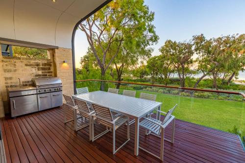 a patio with a table and chairs on a deck at Aqua Resort Busselton in Busselton