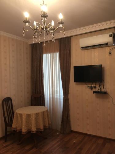 a dining room with a table and a chandelier at Apartment Barita in Tbilisi City