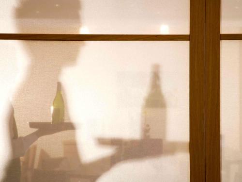 a window with a shadow of a building on a wall at Mercure Hotel Frankfurt Eschborn Ost in Eschborn