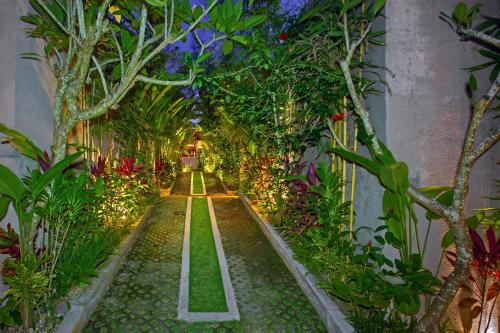 an indoor garden with plants and a walkway at Anusara Luxury Villas in Ubud
