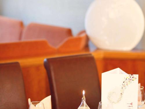 a candle sitting on top of a table with chairs at Mercure Hotel Bad Duerkheim An Den Salinen in Bad Dürkheim