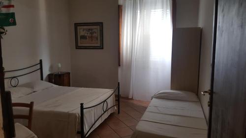 a small bedroom with two beds and a window at Casa di Alfredo Affittacamere in Siena