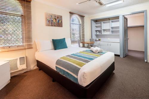 a bedroom with a large bed in a room at The Beach Motel Hervey Bay in Hervey Bay