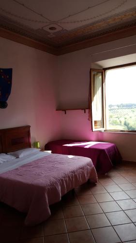 a bedroom with two beds and a large window at Casa di Alfredo Affittacamere in Siena