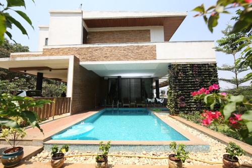 ロナバラにあるVilla 41 by StayVista - A chic retreat with a pool, poker table, and a theater roomの家の前のプール