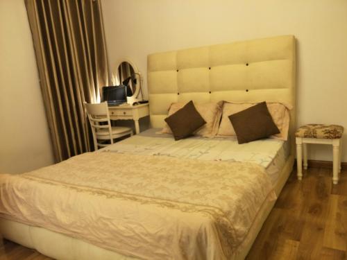 a bedroom with a large bed and a desk at Nancy Vung Tau in Vung Tau