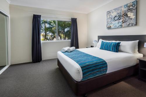 Tempat tidur dalam kamar di The Beach Motel Hervey Bay