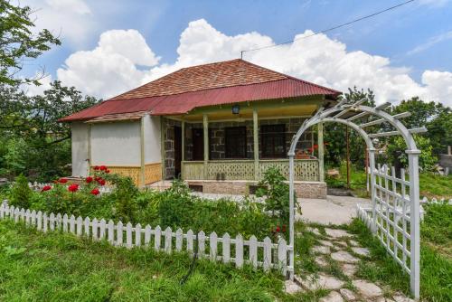 una pequeña casa con una cerca blanca delante de ella en Holiday Home Ruben en Odzun