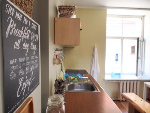 a kitchen with a sink and a chalkboard on the wall at Amber Private Rooms in Rīga