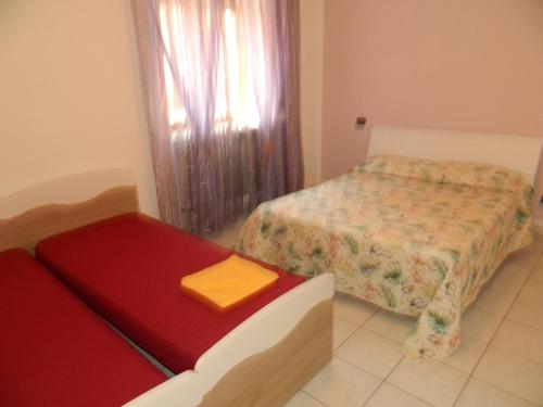 1 dormitorio con 1 cama y un banco con un objeto amarillo en Appartamento Alba, en Mozzate