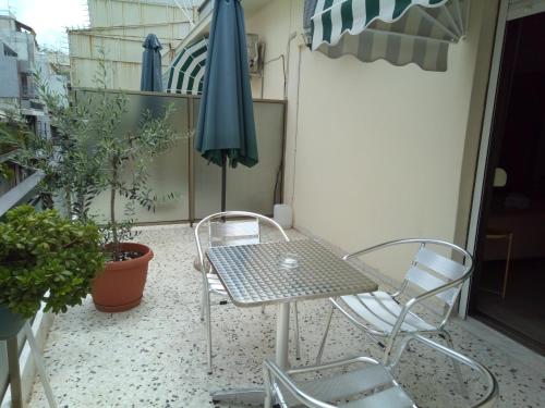 a table and chairs on a balcony with an umbrella at Zappion Hotel in Athens