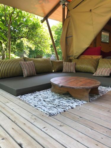 a couch with a coffee table on a deck at Campo Portakal Eco Glamping in Cıralı