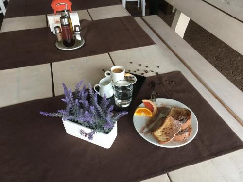 a table with a plate of food and a cup of coffee at Glavatarski Han in Glavatartsi