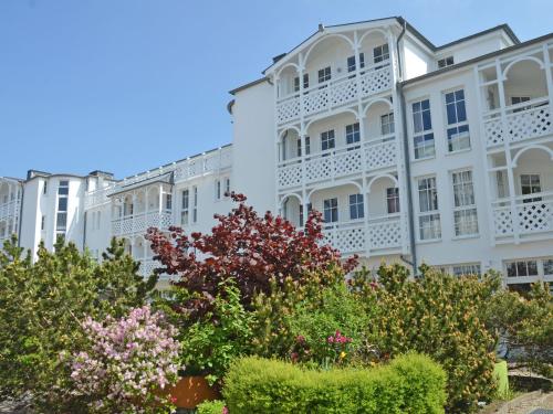 a white building with flowering bushes in front of it at Seepark Sellin - Apt. 382 in Ostseebad Sellin