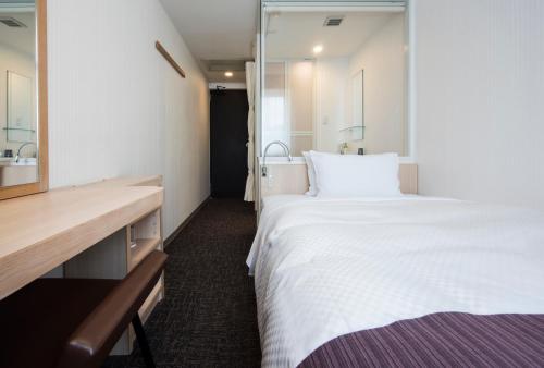 长崎Nagasaki Bus Terminal Hotel的卧室里有一张白色的大床和一个水槽