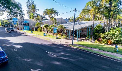 a street with a car driving down a street at The Beach Motel Hervey Bay in Hervey Bay
