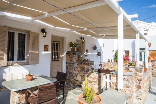 a patio with a table and a stone wall at Irini pension in Platis Yialos Sifnos