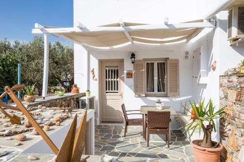 a patio with a table and chairs and an umbrella at Irini pension in Platis Yialos Sifnos