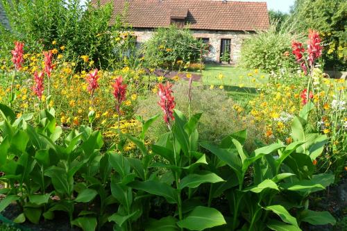 a garden with flowers and a house in the background at Folwark Anna in Kamienica Polska