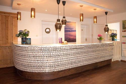 a lobby with a stone counter with pendant lights at Hotel Berlin Tegernsee in Rottach-Egern