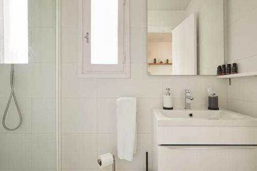 バルセロナにあるEixample Apartment BCNの白いバスルーム(シンク、シャワー付)