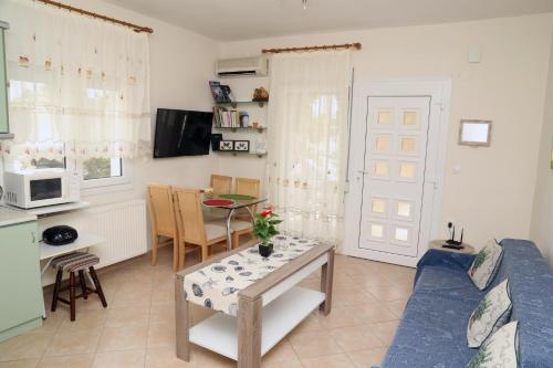 a living room with a blue couch and a table at SeaSide II family appartment in Keramotí