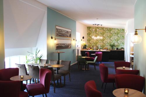 a restaurant with tables and chairs and a bar at Home Hotel Drott in Karlstad