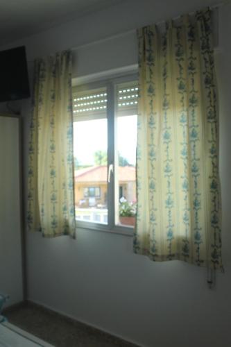 a window in a room with curtains in a room at Mar de Rosas in O Grove