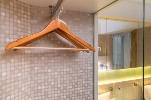 a wooden hanger in a bathroom with a mirror at Silka Seaview Hotel in Hong Kong