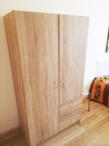 a wooden cabinet in a room with a bed at Couple getaway to a freshly renovated apartment in Pärnu