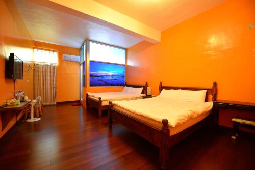 1 dormitorio con 2 camas y ventana grande en 鹽舍休閒民宿 en Beimen