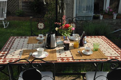 uma mesa com pratos e copos em cima em La Pie Grièche em Coucy