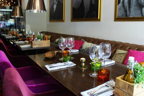 a long table in a restaurant with wine glasses on it at Home Hotel Drott in Karlstad