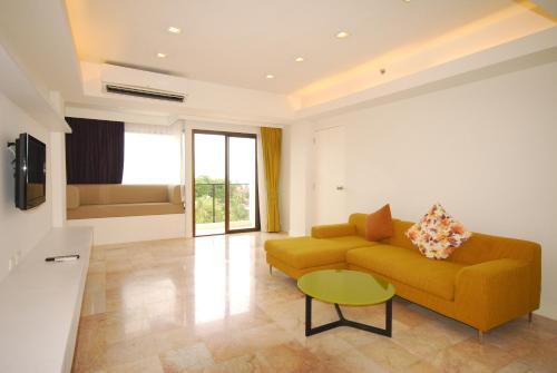 a living room with a couch and a table at Samui Verticolor in Chaweng